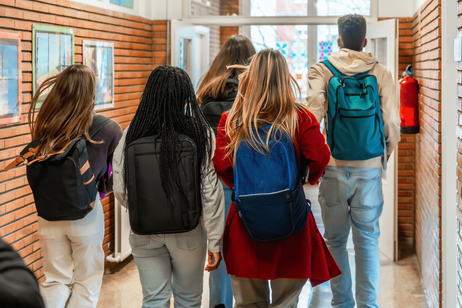 Ragazzi di Scuola secondaria di primo grado di spalle che camminano nel corridoio della scuola