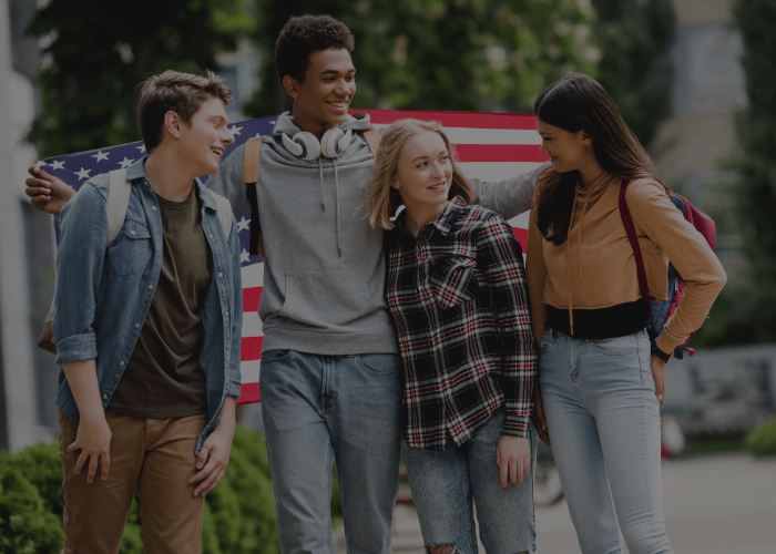 Adolescenti felici e sorridenti che tengono in mano una bandiera americana e parlano