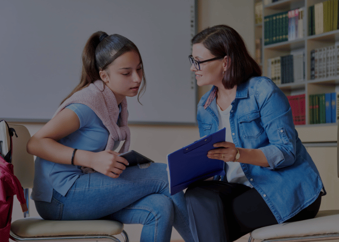 Insegnante parla con una studentessa adolescente e la aiuta